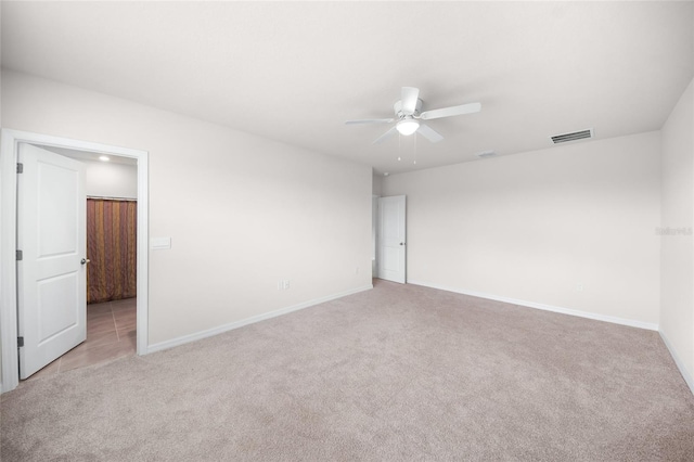 spare room with light colored carpet and ceiling fan