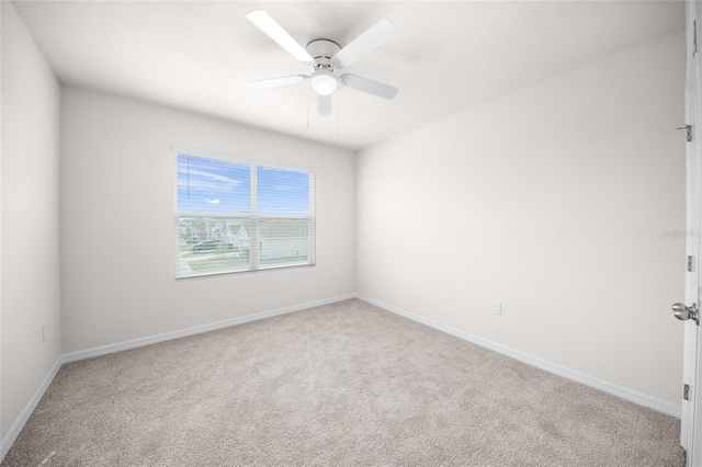 empty room featuring ceiling fan and light colored carpet