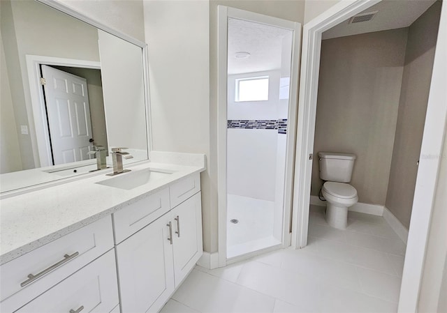 bathroom with tile patterned floors, vanity, toilet, and walk in shower