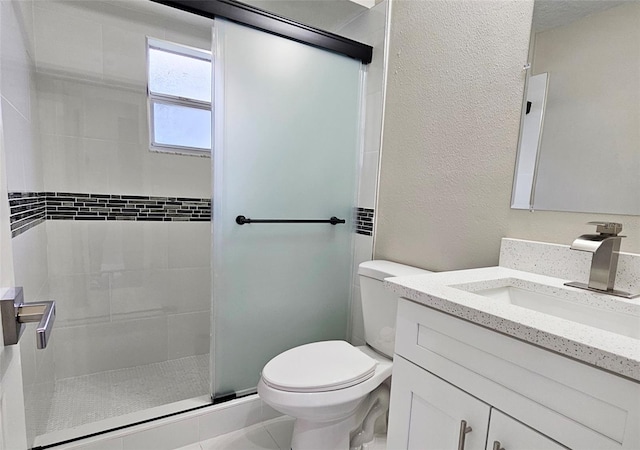 bathroom with tile patterned floors, vanity, toilet, and a shower with door