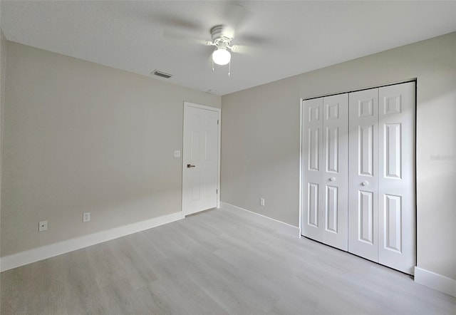 unfurnished bedroom featuring a closet, light hardwood / wood-style flooring, and ceiling fan