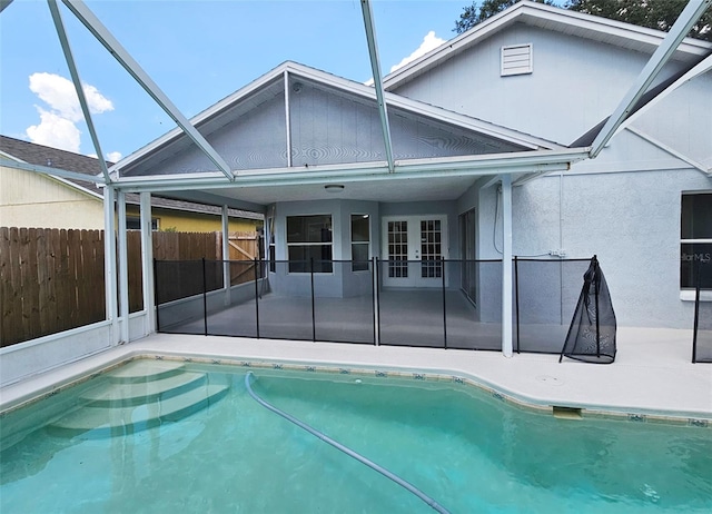 view of swimming pool featuring a lanai, a patio, and french doors