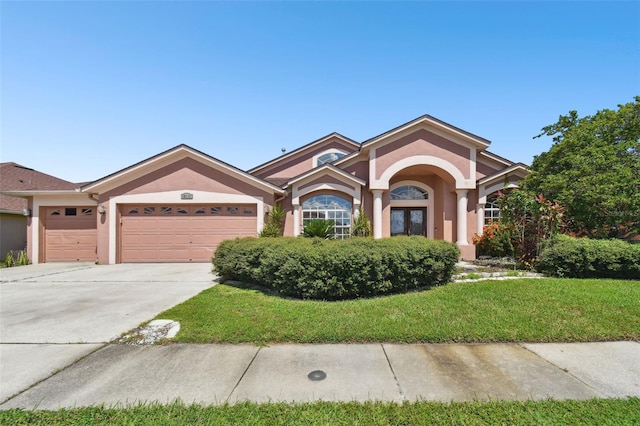 view of front of home with a garage and a front lawn