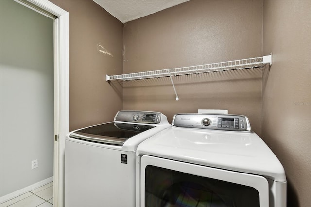 washroom featuring a textured ceiling, independent washer and dryer, and light tile patterned flooring