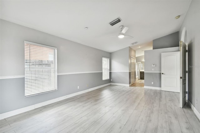 interior space featuring ceiling fan, light hardwood / wood-style flooring, vaulted ceiling, and a healthy amount of sunlight