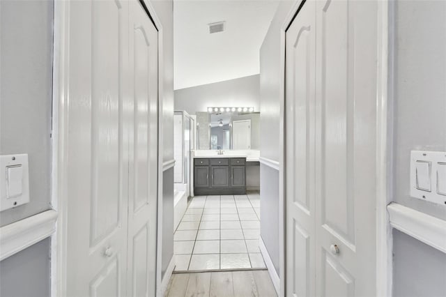 bathroom with vanity, vaulted ceiling, and hardwood / wood-style flooring