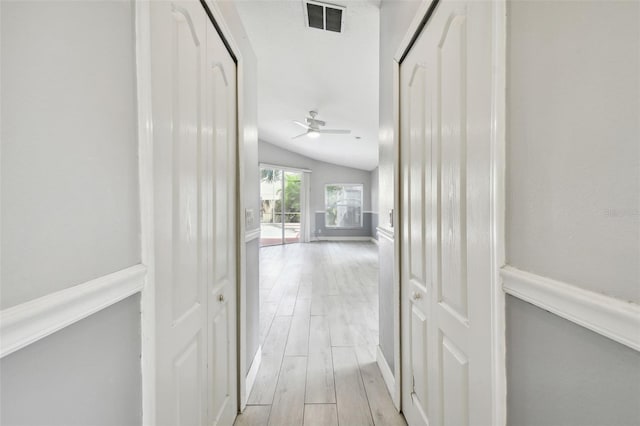 corridor featuring light hardwood / wood-style floors and lofted ceiling