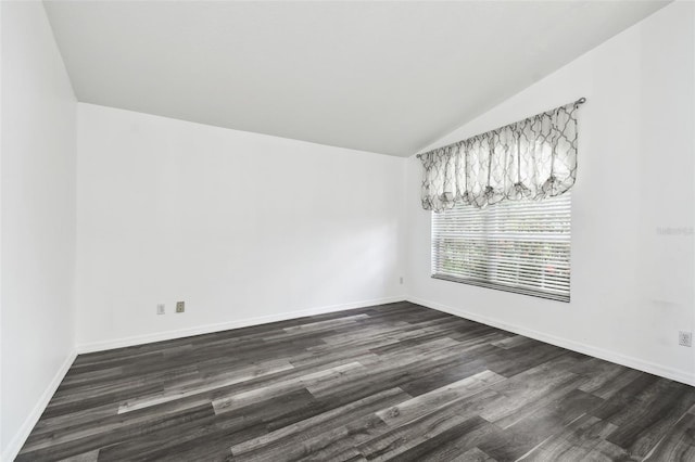 empty room featuring vaulted ceiling and dark wood-type flooring