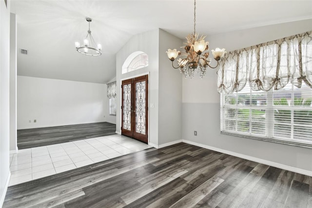 entryway with wood-type flooring, vaulted ceiling, and a chandelier