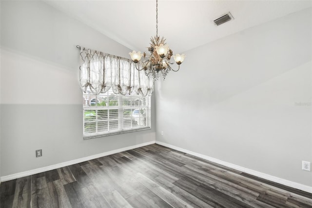 spare room featuring vaulted ceiling, a chandelier, and dark wood-type flooring