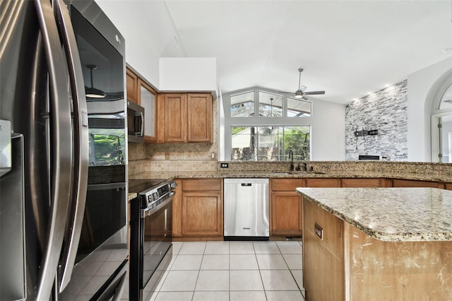 kitchen with light tile patterned flooring, stainless steel appliances, lofted ceiling, ceiling fan, and sink