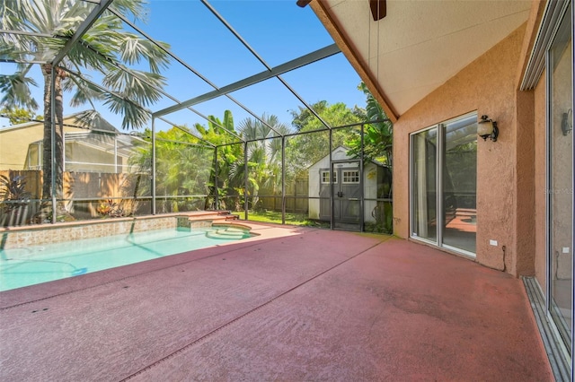 view of swimming pool featuring a patio, glass enclosure, a shed, and a hot tub