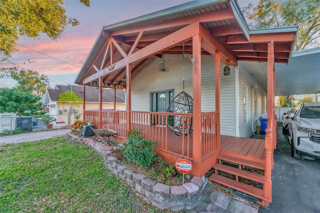 deck at dusk featuring a lawn