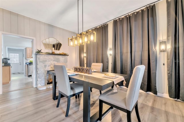 dining space featuring light hardwood / wood-style flooring and a fireplace