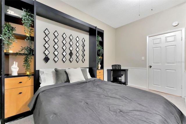 bedroom featuring light carpet and a textured ceiling