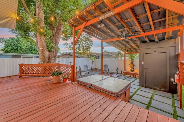 deck at dusk featuring ceiling fan