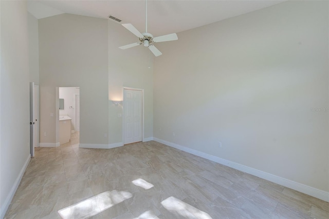 unfurnished bedroom featuring ceiling fan, a closet, high vaulted ceiling, and ensuite bath