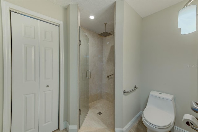 bathroom with a textured ceiling, toilet, and an enclosed shower