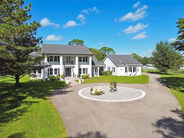 view of front of property featuring a front lawn and a balcony