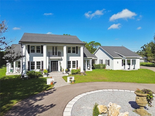 view of front of house with a front lawn and a balcony