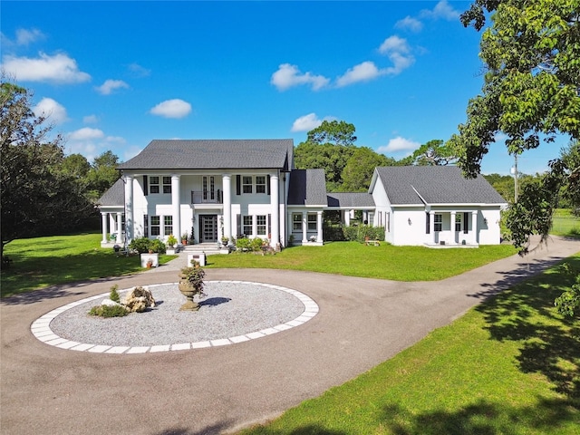 view of front of property with a front yard and a balcony