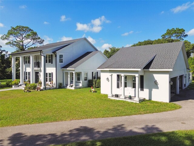 back of house with a balcony and a yard