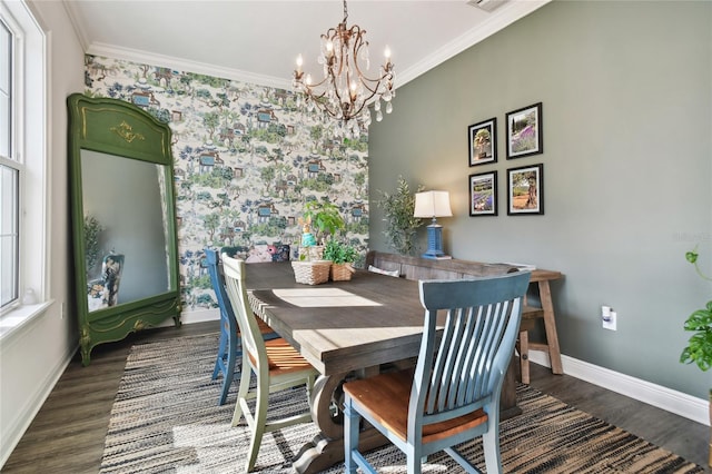 dining space featuring crown molding, an inviting chandelier, and dark hardwood / wood-style flooring