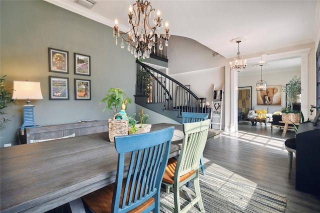 dining room with wood-type flooring, an inviting chandelier, and ornamental molding