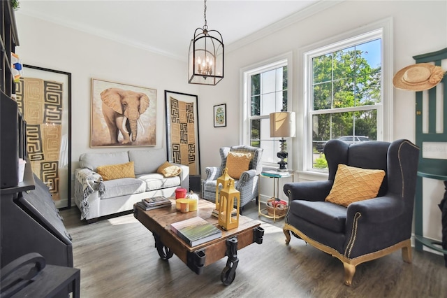 living area with a chandelier, dark hardwood / wood-style flooring, and ornamental molding