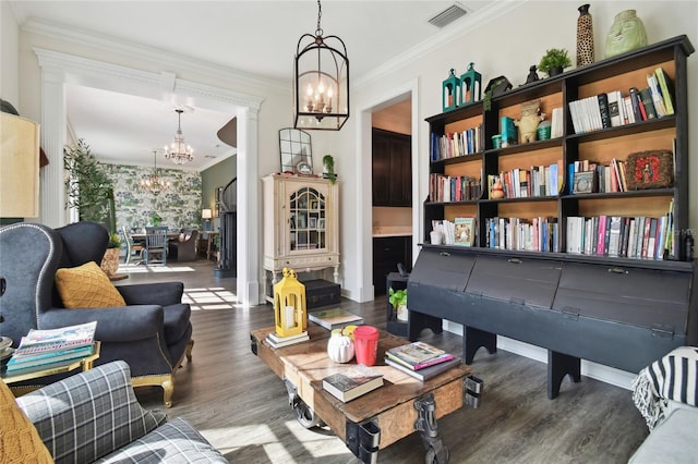 sitting room with dark wood-type flooring, a chandelier, and ornamental molding