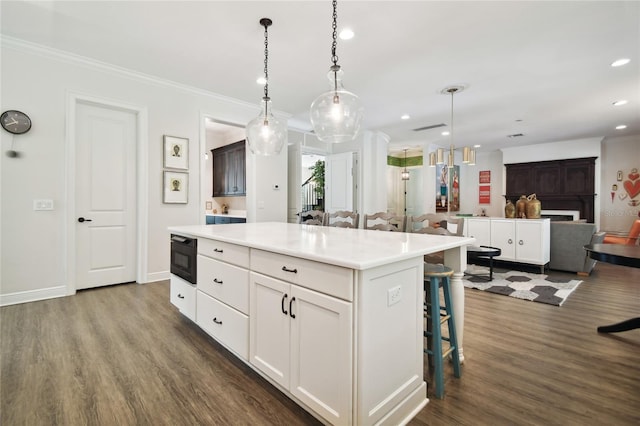 kitchen featuring white cabinets, a kitchen bar, dark hardwood / wood-style floors, and a kitchen island