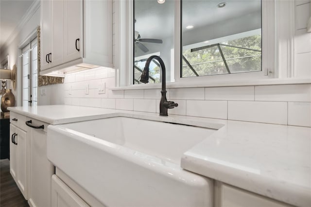 interior details featuring sink, tasteful backsplash, and ceiling fan