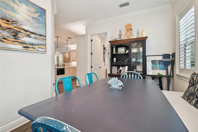 dining room featuring dark hardwood / wood-style flooring, a notable chandelier, and crown molding