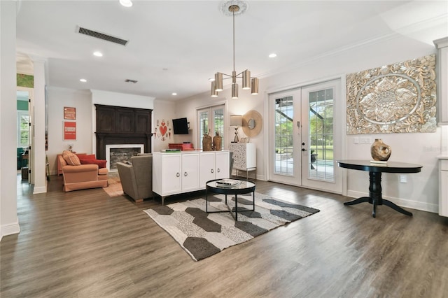 living room with hardwood / wood-style floors, crown molding, and french doors