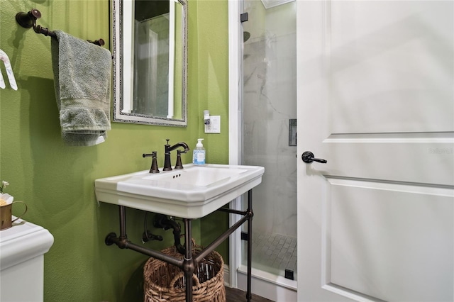 bathroom featuring toilet and a shower with door