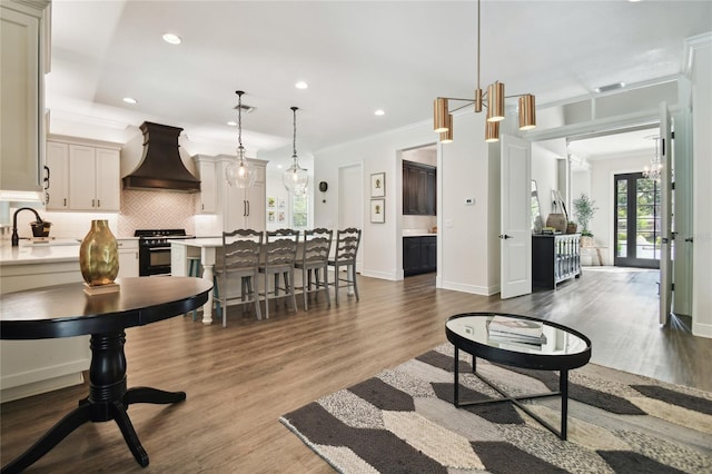 living room with french doors, dark hardwood / wood-style flooring, sink, and crown molding