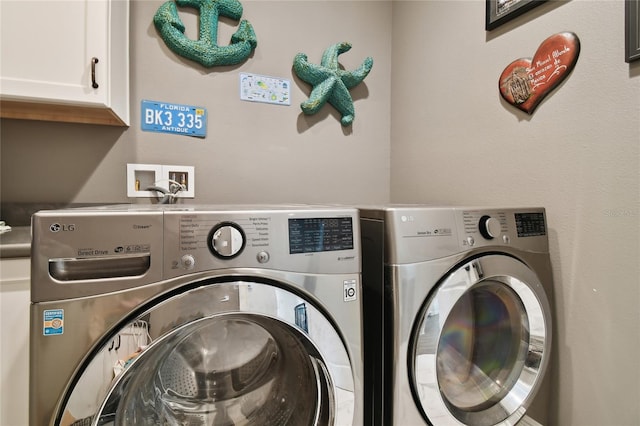 laundry room with cabinets and washer and clothes dryer