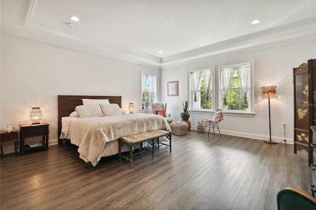 bedroom featuring dark wood-type flooring, a raised ceiling, and ornamental molding