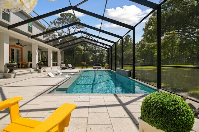 view of pool featuring glass enclosure, a patio area, french doors, and ceiling fan