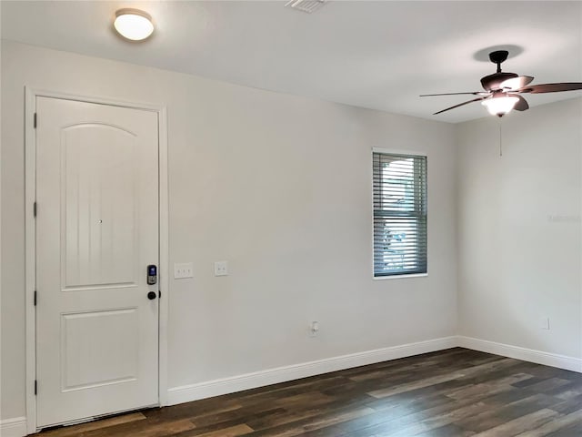 empty room with ceiling fan and dark hardwood / wood-style flooring