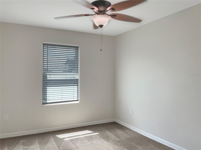 carpeted empty room with a wealth of natural light and ceiling fan