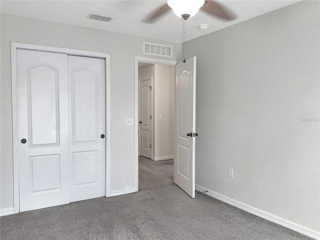 unfurnished bedroom featuring carpet floors, ceiling fan, and a closet