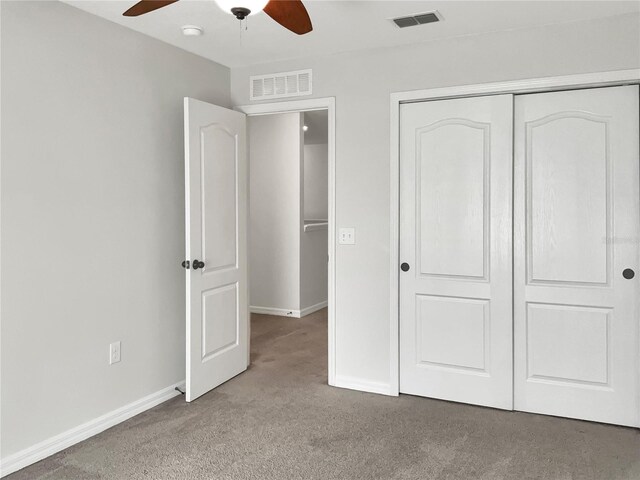 unfurnished bedroom with carpet floors, ceiling fan, and a closet