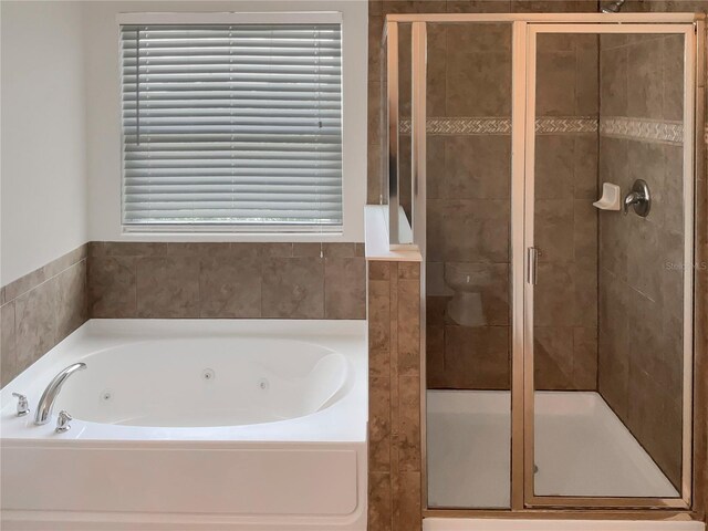 bathroom featuring independent shower and bath