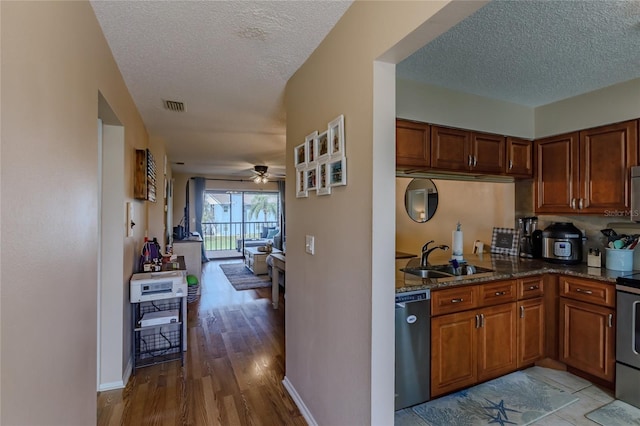 kitchen with ceiling fan, sink, a textured ceiling, and appliances with stainless steel finishes