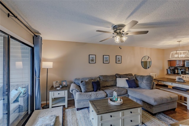 living room with a textured ceiling, light hardwood / wood-style floors, and ceiling fan with notable chandelier