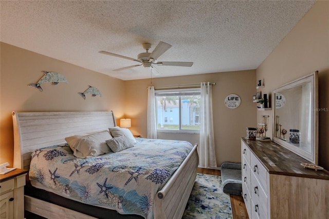 bedroom featuring ceiling fan, a textured ceiling, and light hardwood / wood-style flooring