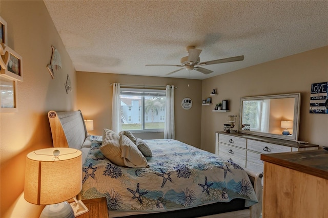 bedroom with ceiling fan and a textured ceiling