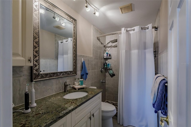 bathroom featuring backsplash, vanity, tile walls, toilet, and curtained shower