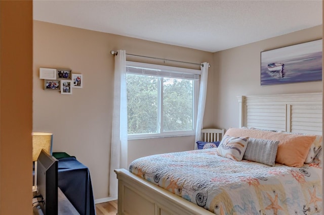 bedroom with hardwood / wood-style floors and a textured ceiling